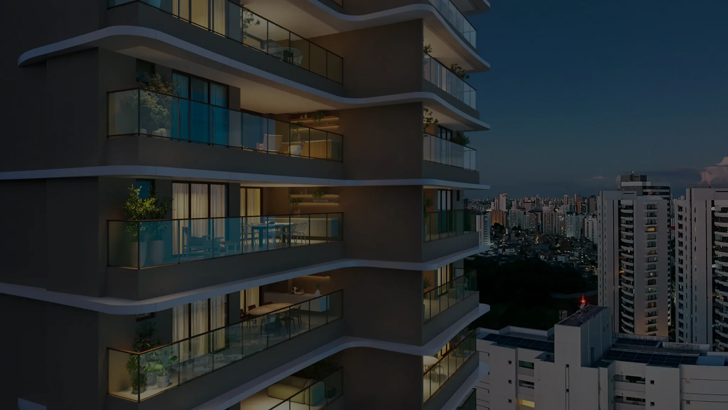 Varandas curvas do Elleve iluminadas ao anoitecer, com a cidade ao fundo